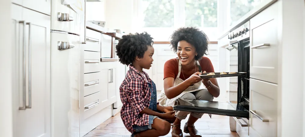 mom and son in kitchen taking something out of the oven